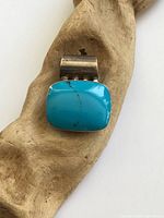 Front view of sterling silver pendant with turquoise cabochon