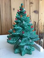 Front view of green ceramic Christmas tree with plastic peg bulbs and base
