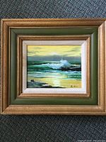 Front view of framed seascape painting, signature visible