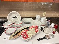 All dinnerware, bread baskets, napkins and gadgets grouped on counter