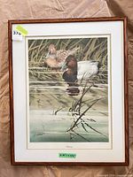 Framed print showing two ducks on water, oak wood frame, mat and glazing visible
