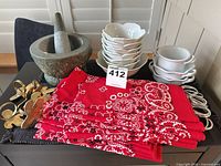 Lot overview showing mortar & pestle, stacked bowls, ramekins, red napkins, and mixed napkin rings