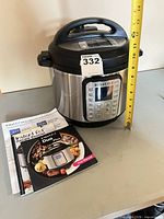 Instant Pot with manuals and tape measure for scale