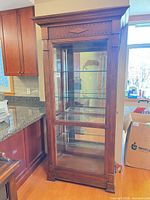 Front angled view of closed cherry curio cabinet