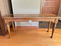 Front view of oak console table showing top, legs, apron