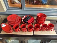 Full set of plates, bowls, mugs, serving pieces and napkins displayed