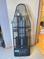 Rowenta ironing board folded upright against wall