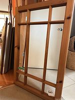 Front view of paneled wood wall mirror leaning against wall