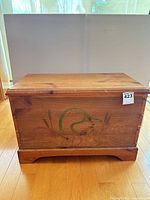 Front view of pine blanket chest with duck carving and lot tag