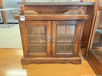 Front view of brown solid wood cabinet with two glass doors