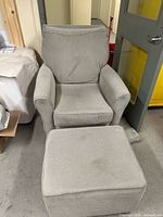gray upholstered rocking chair with ottoman front view