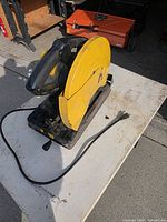 Left front view of yellow 14-in chop saw on table