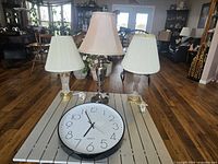 All three lamps with shades and wall clock on table