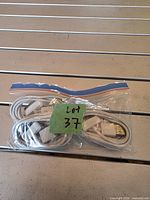 Zip-lock bag containing five coiled white USB-A to Lightning cables