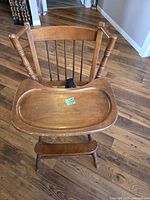 Front view of wooden highchair with tray attached