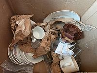 Packed box view with saucers, cups and protective paper