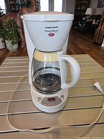 Front view showing full unit, brand name, control panel, carafe and cord