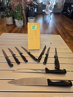 Eight knives laid out with wood block