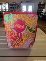 Front of mini fridge showing Coca-Cola graphics and handle
