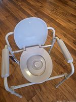 Top view of commode with lid open on metal frame
