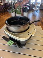 Electric skillet base stacked with stainless pot and divided insert
