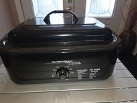 Front view of Hamilton Beach roaster oven showing temperature dial and branding