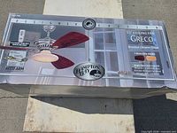 Front of sealed box showing Hampton Bay Greco ceiling fan, brushed chrome finish, 52" size