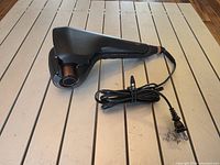 Curler angled view showing ceramic chamber, handle and cord
