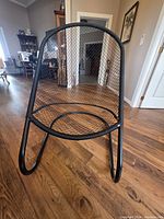 Front view showing mesh seat, back, and tubular frame.