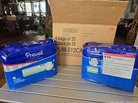Two sealed blue Prevail bags with shipping carton showing printed "4 bags of 20"