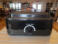 Front view of roaster oven with lid closed showing brand name and temperature dial