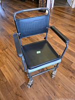 Front view of Nova wheeled drop arm commode showing seat, arms, casters