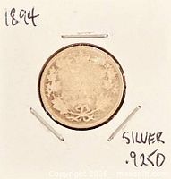 Entire coin in cardboard holder showing reverse wreath design