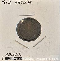 Coin in cardboard holder showing reverse side with wreath and numeral