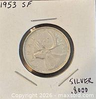 Coin reverse with caribou and date visible in holder