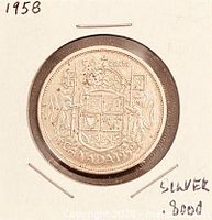 Coin in cardboard flip showing reverse, handwritten notations