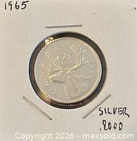 Front view of 1965 Canadian 25-cent coin in holder showing reverse caribou design