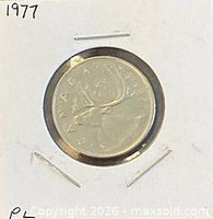 Reverse of 1977 Canadian 25-cent coin in holder showing caribou design