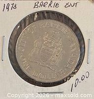 Coin in flip, obverse visible with handwritten date on holder