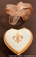Heart porcelain trinket box closed beside glass ribbon sculpture