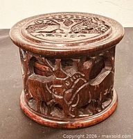 Cylindrical carved wooden holder, top and side views show wildlife motifs