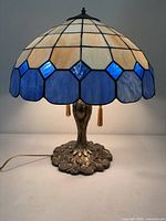 Lamp lit showing stained glass shade and metal base