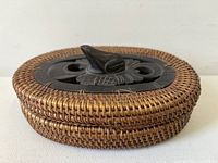 Top view of oval woven basket showing carved wood frog lid