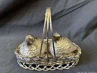 Two bird-form shakers seated in woven basket