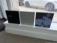 Front view of three square panels showing text and floral designs