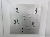 Front view of square metallic canvas with abstract figures