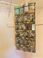 Full view of hanging multi-pocket organizer filled with jewelry