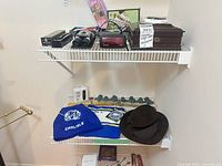 Shelf view showing hats, wall rack, shoe horn, binoculars, clock radio, boxes