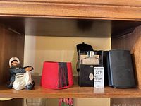 All items grouped on shelf: fez, flask set, sailor figurine, one speaker visible