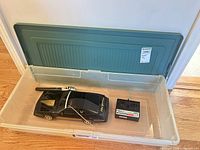 Overall view of car, controller and microphone inside storage bin